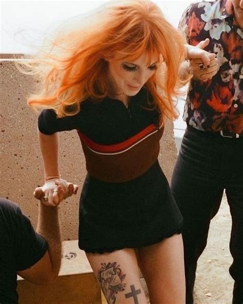 A Woman With Red Hair And Tattoos On Her Leg