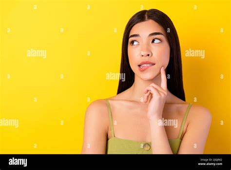 Photo Of Minded Pretty Malaysian Lady Finger Touch Chin Biting Lips Look Empty Space Isolated On