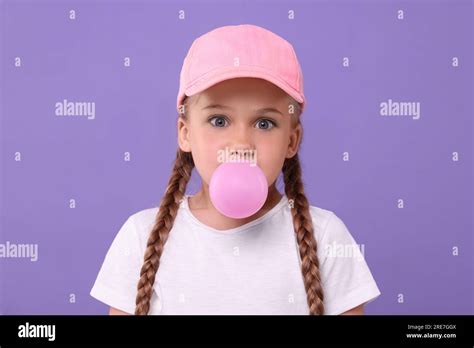 Surprised Girl Blowing Bubble Gum On Purple Background Stock Photo Alamy
