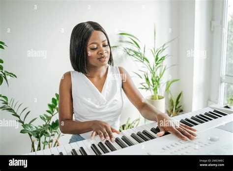 Young Woman Playing Piano At Home Stock Photo Alamy