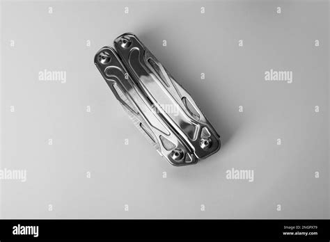 Compact Portable Metallic Multitool On White Background Top View Stock