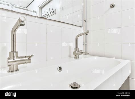 Interior Of Spacious Bathroom With Double Ceramic Sink And Chrome Taps