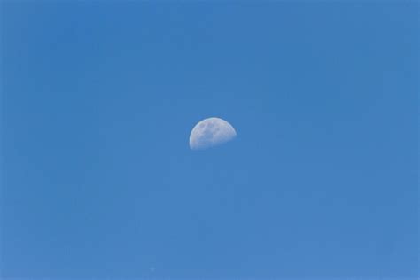 A Horizontal Shot Of A Half Moon Visible During Daylight In The Blue