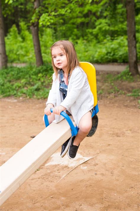 Petite Fille Sur Une Cour De Jeu Enfant Jouant Dehors En été Image