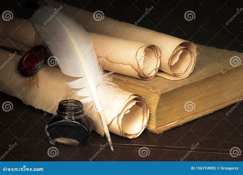 Parchment Scrolls And Inkwell With A Pen On The Background Of The Book