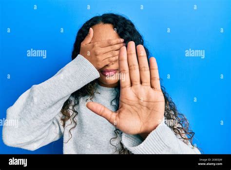 Young Latin Woman Wearing Casual Clothes Covering Eyes With Hands And