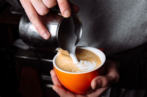 Premium Photo Barista Pours Warm Milk Into Coffee