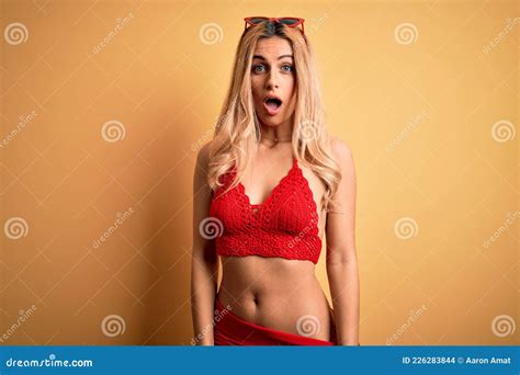 Joven Y Hermosa Mujer Rubia De Vacaciones Usando Bikini Sobre Un Aislado Fondo Amarillo