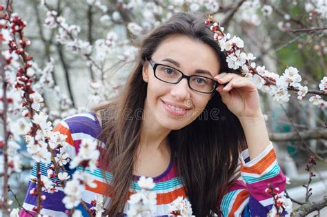 Portrait Of Smiling Caucasian Brunette Woman In Spring Blossom Garden