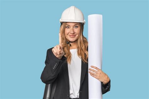 Premium Photo Blonde Architect With Plans In Studio Showing Number
