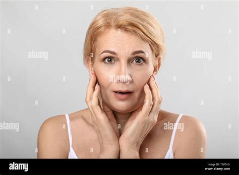 Portrait Of Surprised Mature Woman On Light Background Stock Photo Alamy