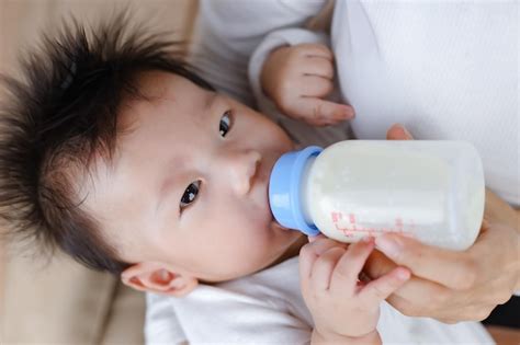 Premium Photo Mother Feeding Baby With Milk Bottle