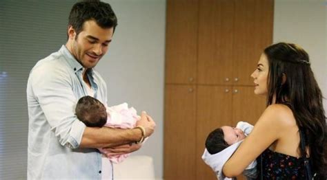 A Man Holding A Baby While Standing Next To A Woman