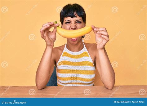 Una Adolescente De Brunette Sosteniendo Banana Como Sonrisa Divertida Enojada Y Furiosa Gritando