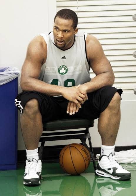 A Man Sitting In A Chair With A Basketball