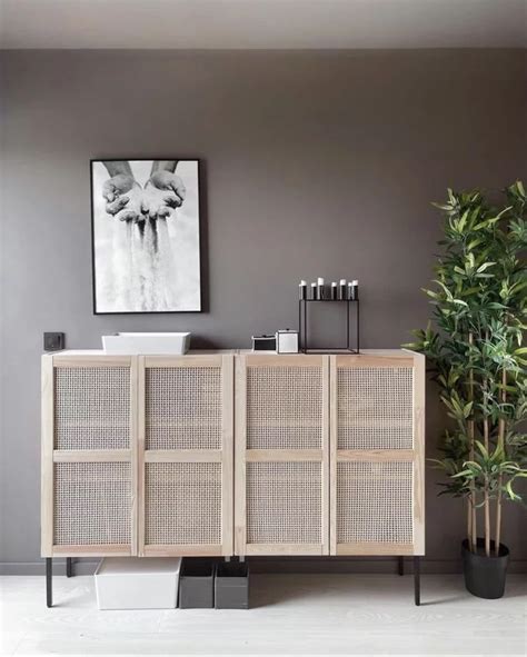 A Living Room With Grey Walls And A White Sideboard Next To A Potted Plant