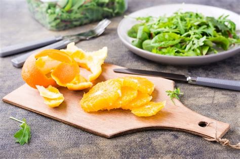 Naranja Pelada Y Cortada En Rodajas Sobre Una Tabla De Cortar Y Una