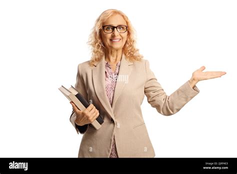 Mature Female Teacher Holding Books And Gesturing With Hand Isolated On