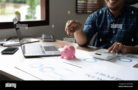 Happy Man Hand Putting Money Coin Into Piggy For Saving Money Wealth