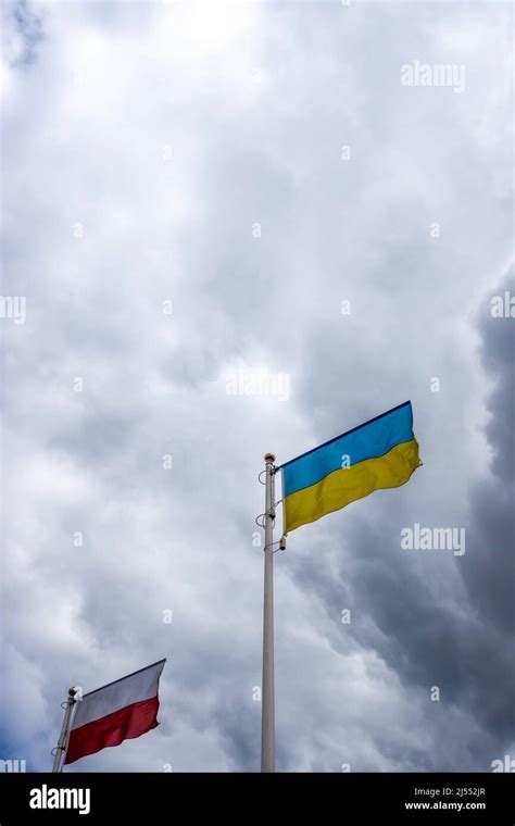 Polish And Ukrainian Flags Wave On The Background Of Cloudy Dramatic