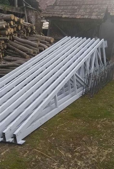 A Large White Metal Structure Sitting On Top Of A Grass Covered Field