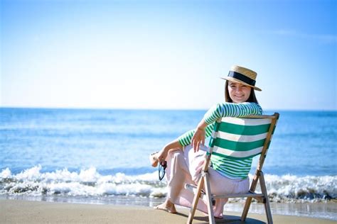 Chica Disfruta De La Puesta De Sol Junto Al Mar En Una Tumbona Vintage