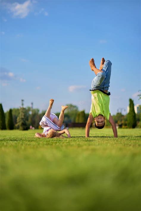 Deux Enfants Souriants Et Heureux Qui Tombent Sur L Herbe Verte Joyeux