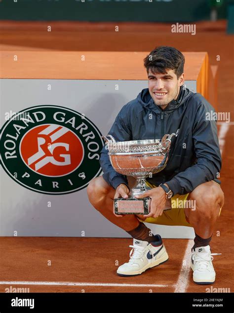 French Open Winner Carlos Alcaraz With The Trophy Squatting Next