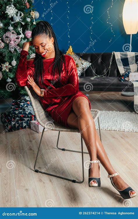 Happy African American Woman Sitting On A Chair Smiling And Looking