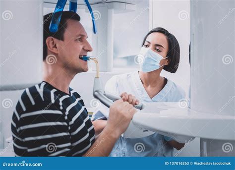 Serious Brunette Dentist Looking At Her Patient Stock Image Image Of