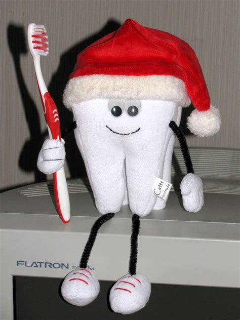 A Toothbrush Holder With A Santa Hat On It And A Toothbrush In Its Mouth