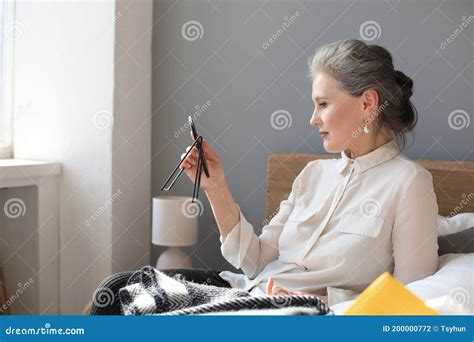 Mature Woman Looking At Mirror And Touching Face At Home Stock Photo Image Of Beauty Senior