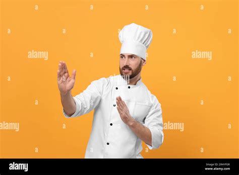 Emotional Mature Male Chef On Orange Background Stock Photo Alamy