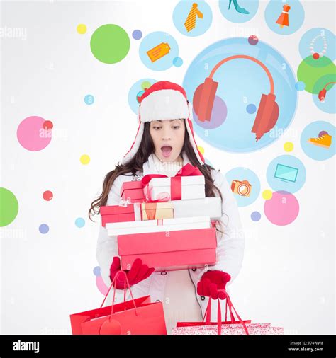 Composite Image Of Surprised Brunette In Winter Clothes Holding Many