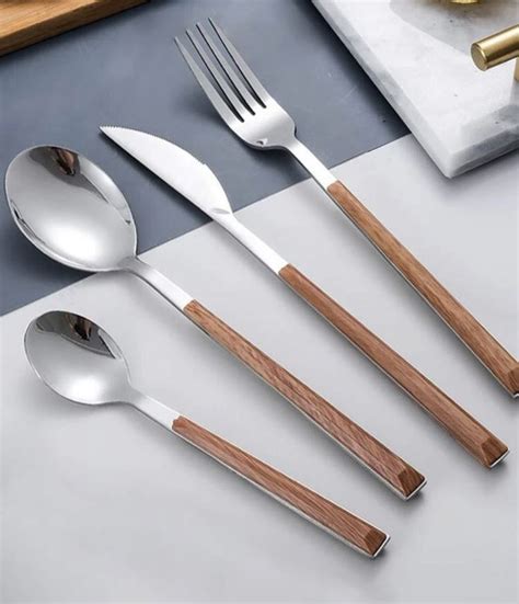 Five Spoons Two Forks And One Knife On A Cutting Board Next To A Cookie