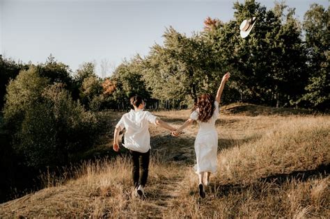 Premium Photo Loving Couple Walks And Runs At Sunset In The Summer On The Nature Brunette