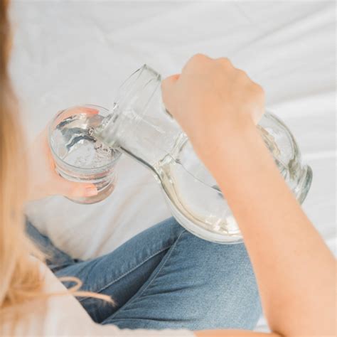 Fille Blonde Remplissant Un Verre D Eau Photo Gratuite