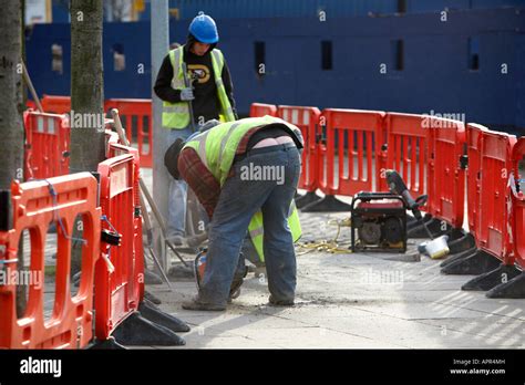 Builder Bending Over Showing Bum Crack Using Grinder To Cut Paving