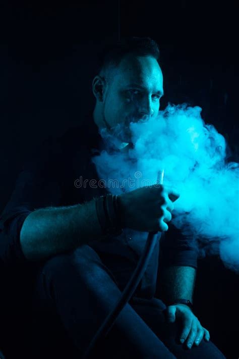 Hombre Fumando Pipa Tradicional De Narguile Con Luz Azul Imagen De