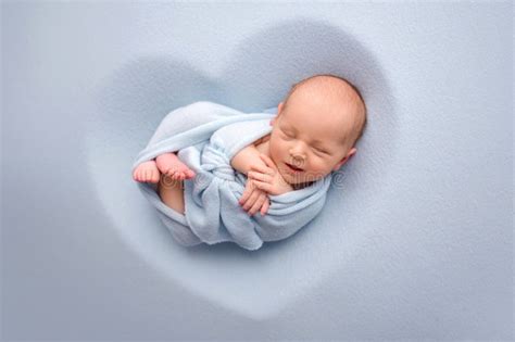 A Cute Newborn Boy In The First Days Of Life Sleeps Naked On A Blue Background Stock Image