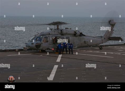 Sailors Support A MH 60 Seahawk Helicopter Aboard USS Lewis B Puller