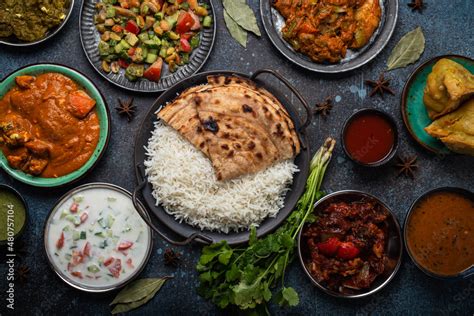 Assorted Indian ethnic food buffet on rustic concrete table from above ...