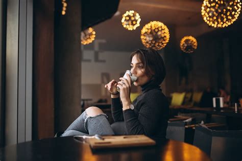 Mujer tomando café en una cafetería Foto Premium