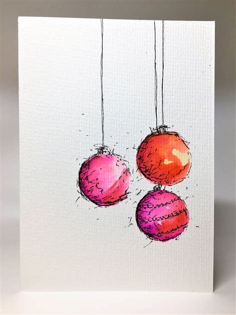 Three Red And Pink Ornaments Hanging From Strings On A White Card With