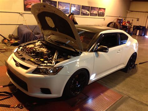 A White Car With Its Hood Open In A Garage