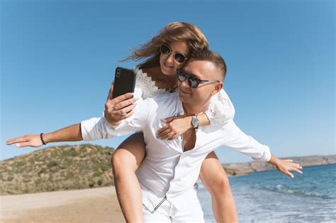 Joven Pareja Feliz Tomando Selfie En La Playa Foto Premium