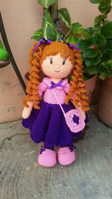 A Crocheted Doll Sitting Next To A Potted Plant