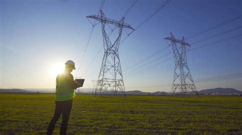 ingénieur électricien travaillant devant des lignes à haute tension un