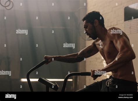 Fit Young Man Using Exercise Bike At The Gym Fitness Male Using Air