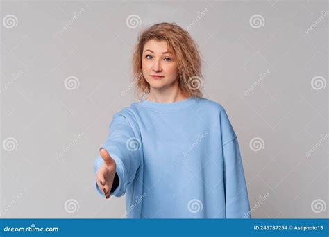 Modern Mature Woman With Curly Blonde Hair Offering Handshake As